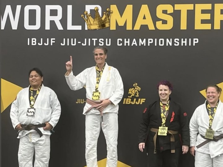 Hillary Guzman standing on an IBJJF championship podium.