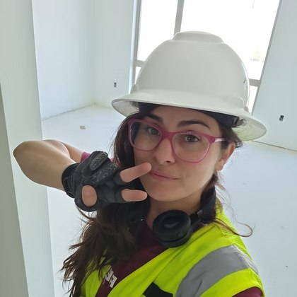Stacy Salazar wearing a hard hat and pink glasses.